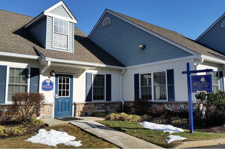 The Resiliency Center building exterior, with its blue door, blue shutters, and Resiliency Center sign