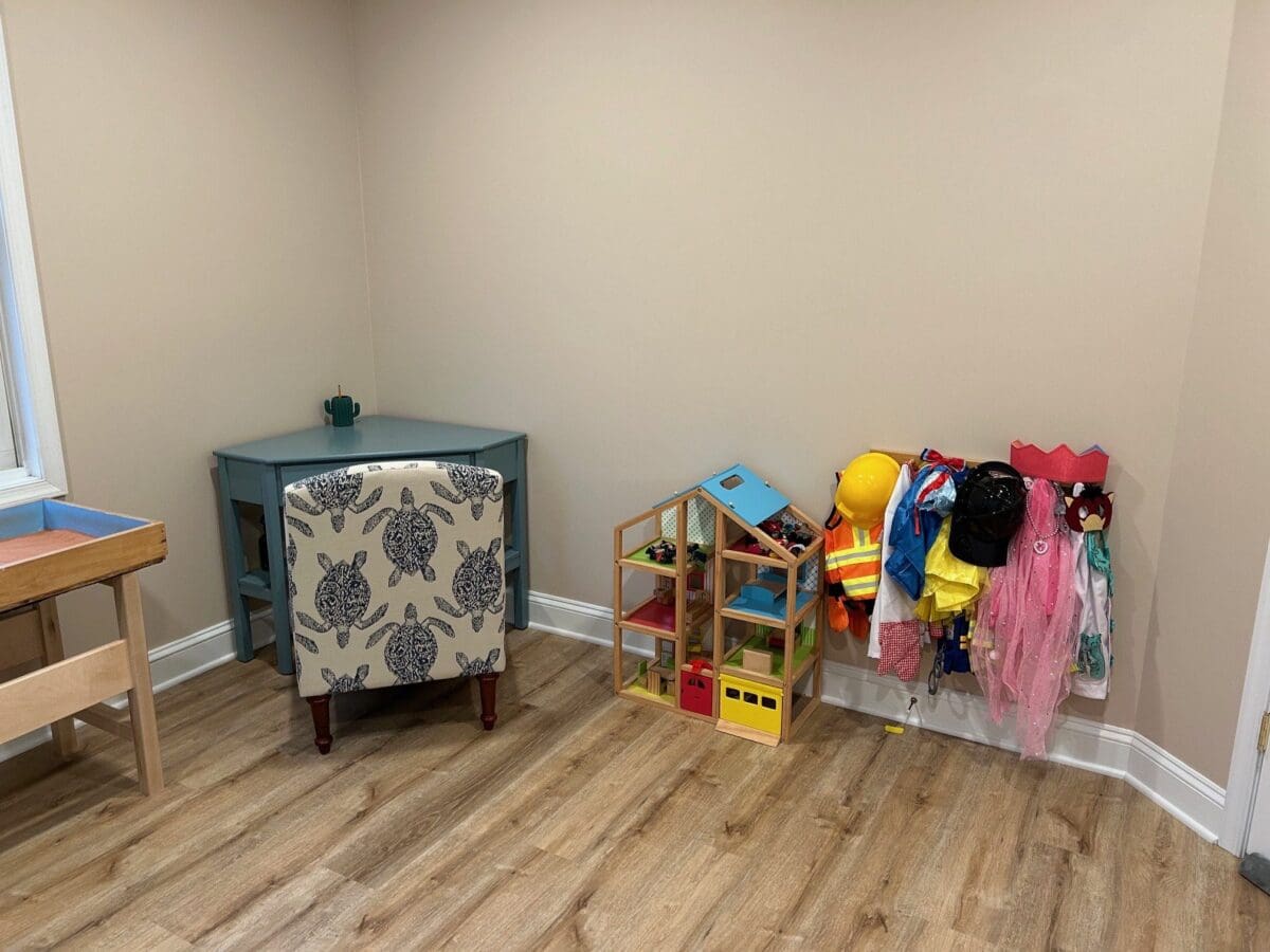 Play therapy room with dollhouse and dress-up area at the Schwenksville office.