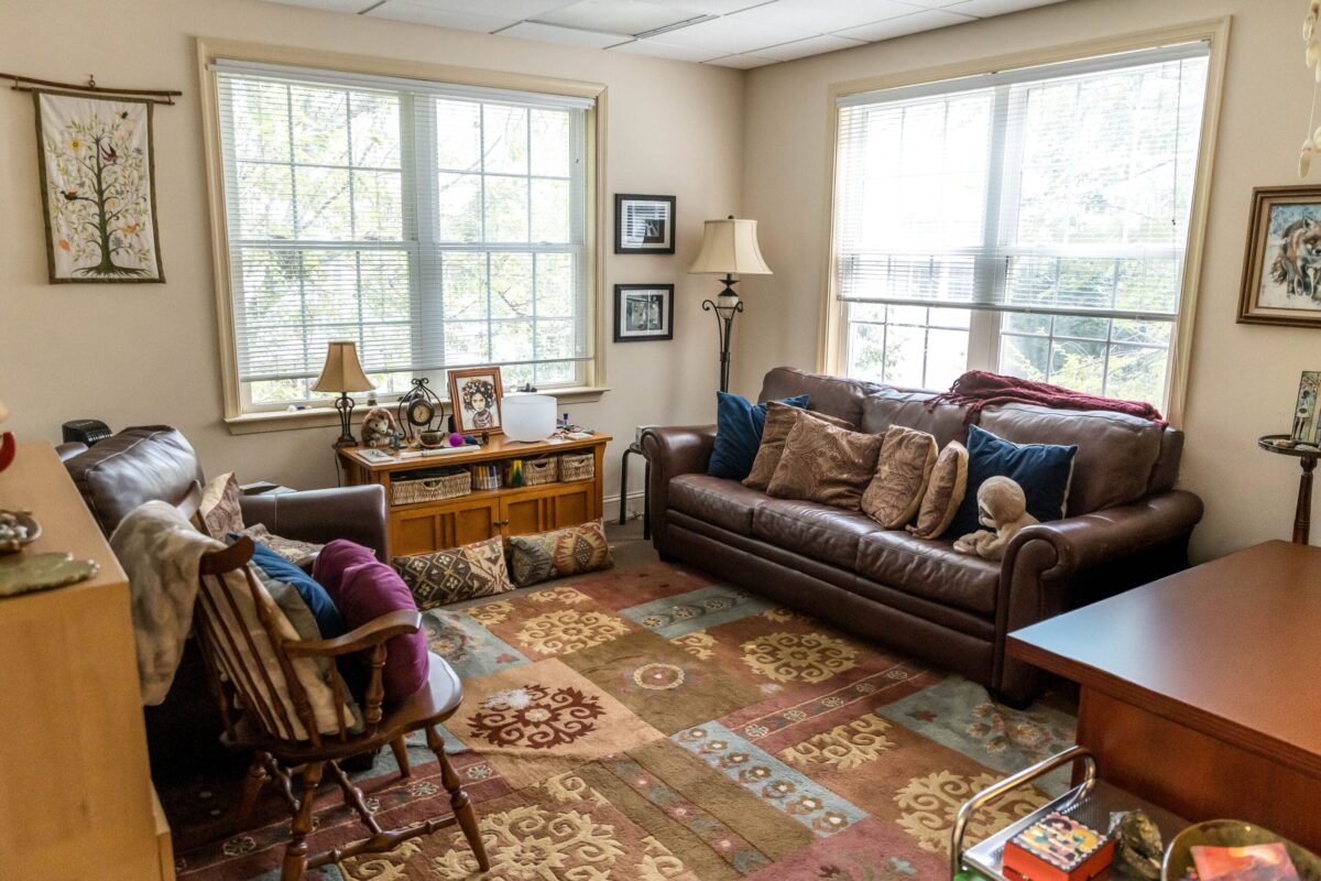 Elizabeth Venart's counseling office at the Flourtown location, with leather sofas, warm lamps, and large windows.