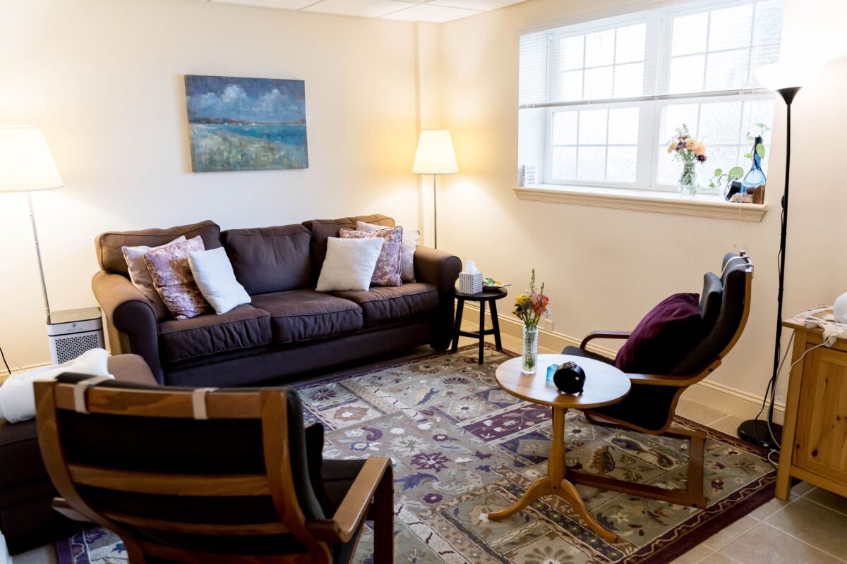 Downstairs counseling office at the Flourtown location with a comfortable sofa, wooden armchairs, and soft natural light.