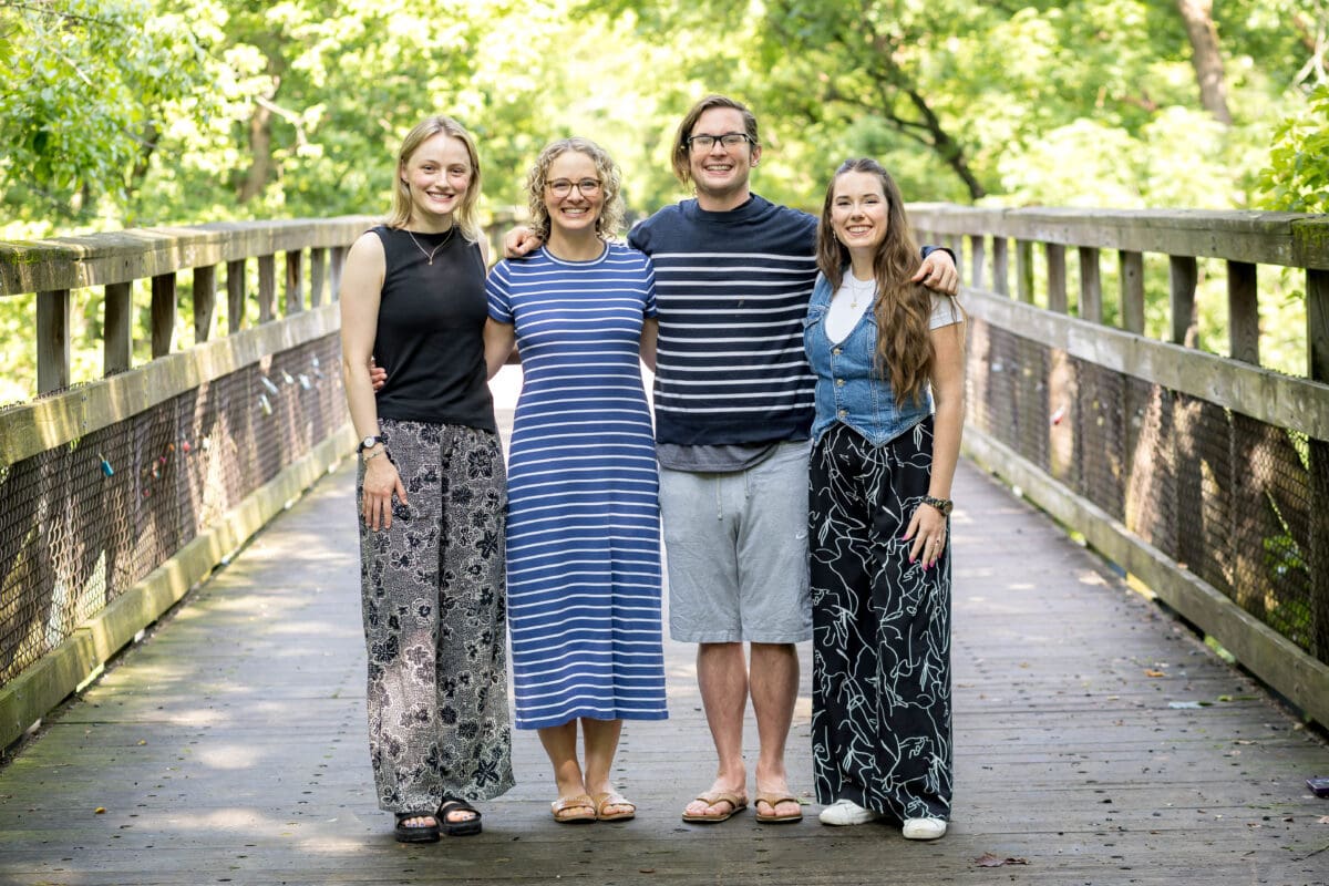 The Schwenksville practitioners of The Resiliency Center standing together on a wooden footbridge